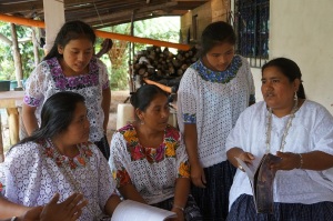 Amalia sharing her copies of Traditional Weavers of Guatemala with some of the other weavers in their coop. 